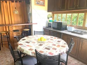 a kitchen with a table with a bowl of fruit on it at CABAÑA PUNTA NEGRA MANZANO HISTORICO TUNUYAN MENDOZA in Los Árboles