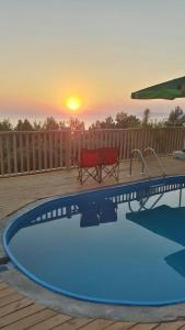 uma piscina com um banco e um pôr-do-sol ao fundo em Esila bungalow sea and nature wiev em Fethiye