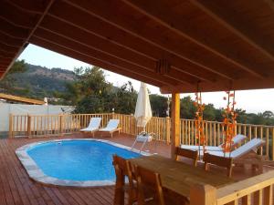 una piscina en una terraza con sillas y sombrilla en Esila bungalow sea and nature wiev en Fethiye