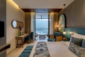 a hotel room with a bed and a living room at Flora Misty Falls Athirappilly in Athirappilly