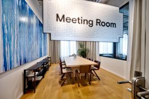 una sala de reuniones con mesa y sillas en Habyt-The Waterfront, en Berlín