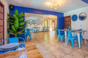 a dining room with blue chairs and tables at The Villa Manor & Spa in Bela-Bela