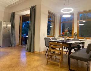 a kitchen and dining room with a table and a refrigerator at Ferienwohnung Blaues Haus in Schmalkalden