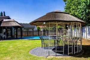 a gazebo with tables and chairs in a yard at House Musantwi in Kroonstad