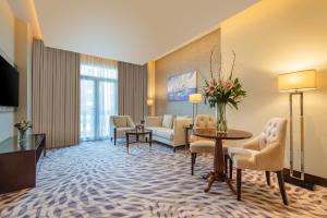 a hotel room with a lobby with a waiting area at Riviera Rayhaan by Rotana Doha in Doha