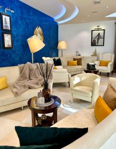 a living room with couches and a blue wall at Erbavoglio Hotel in Rimini