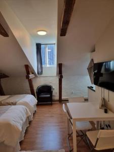 斯德哥爾摩的住宿－Stockholm City Chic-1-Bedroom Loft for 3 - 914，客房设有三张床、一张桌子和一台电视。