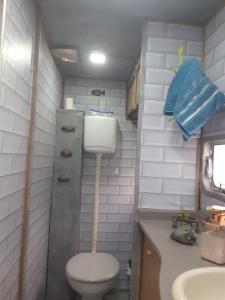 a small bathroom with a toilet and a sink at Traillertuba Yaveh in Ubatuba
