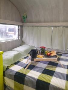 a table with a tray of fruit on a bed in a trailer at Traillertuba Yaveh in Ubatuba