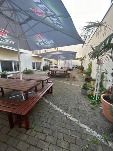 eine Gruppe Picknicktische mit Sonnenschirmen auf einer Terrasse in der Unterkunft Urban Escape Haven in Hannover