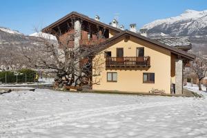 uma casa com varanda na neve em La Vigne De Papagran App1 em Aosta