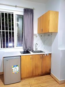 a kitchen with wooden cabinets and a sink and a window at SUNNY HOME in Ho Chi Minh City