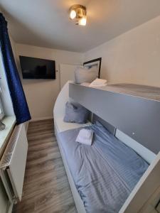 a room with two bunk beds and a tv at Haus Ilse Wohnung 8 in Sankt Andreasberg