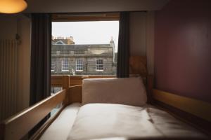 a small bed in a room with a window at Edinburgh Central Accommodation in Edinburgh