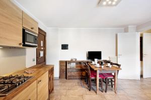 uma cozinha com uma mesa com cadeiras e um fogão em La Vigne De Papagran App2 em Aosta