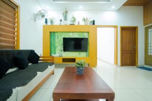 a living room with a couch and a tv at Glendale Hospitality Wayanad in Vythiri