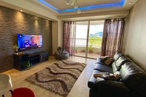 a living room with a couch and a flat screen tv at Alquiler de Apartamento vacacional en la Isla de Margarita in Pampatar