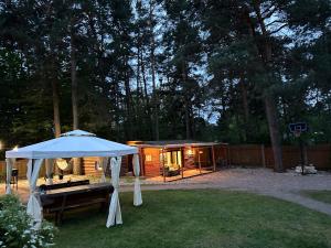 a tent and a bench in a yard with a cabin at House By The Sea With Hot Tub in Rīga