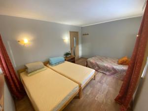 um pequeno quarto com 2 camas num quarto em House By The Sea With Hot Tub em Riga