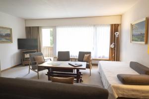 a living room with a couch and a table at Brentschpark Wohnung 72 in Scuol