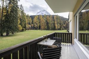 a table on a balcony with a view of a mountain at Brentschpark Wohnung 72 in Scuol