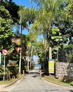 une route avec des palmiers sur le côté d'une rue dans l'établissement Praia do Engenho - Apart Lindo e Novíssimo 30m da praia, à São Sebastião