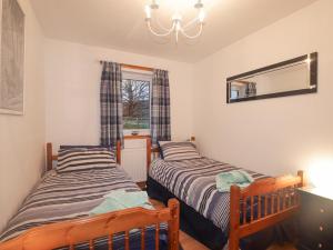 - 2 lits dans une petite chambre avec fenêtre dans l'établissement Roselea, à Broadford