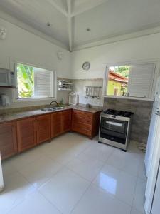 uma cozinha com um fogão, um lavatório e 2 janelas em Villa Rossella em Morro de São Paulo