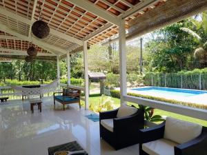 un patio con una hamaca y una piscina en Villa Rossella en Morro de São Paulo