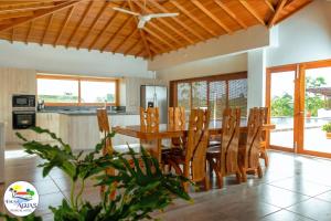a kitchen and dining room with a wooden table and chairs at El Encanto de las Aguas in Necoclí