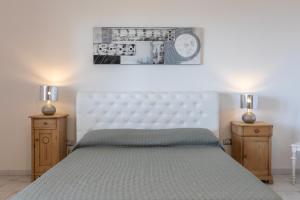 een slaapkamer met een groot bed met twee nachtkastjes bij Villetta Chiara per gruppi - Apulia Home in Ugento