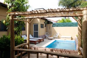 a patio with a swimming pool and a pergola at San Pedro Hotel & Restó in San Pedro