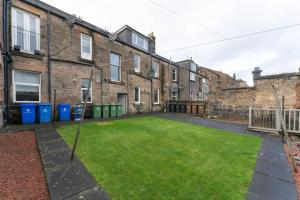an empty yard in front of a brick building at Beautifully Renovated 2 Bedroom Apartment in Stirling