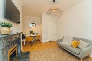 een woonkamer met een bank en een open haard bij Beautifully Renovated 2 Bedroom Apartment in Stirling