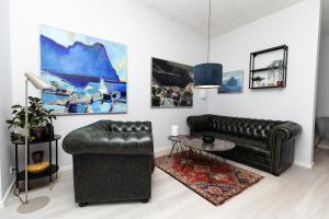 uma sala de estar com um sofá de couro e uma mesa em Charming Artistic Retreat - Panoramic View em Tórshavn