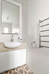 a white bathroom with a sink and a mirror at Balmain Wharf 1 bedroom Apartments in Sydney