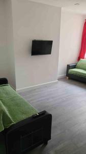 1 dormitorio con 1 cama verde y 1 sofá en ASM London Road Studio Apartments, en Leicester