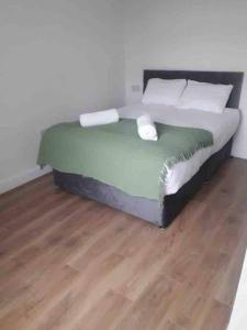 Cama en habitación con suelo de madera en ASM London Road Studio Apartments, en Leicester