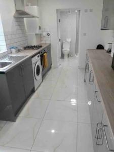 uma cozinha branca com um lavatório e um WC em ASM London Road Studio Apartments em Leicester