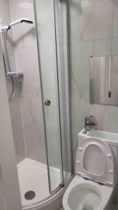 a bathroom with a shower and a toilet with a glass door at ASM London Road Studio Apartments in Leicester