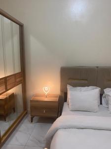 - une chambre avec un lit et une table avec une lampe à incandescence dans l'établissement Nouakchott INN, à Nouakchott