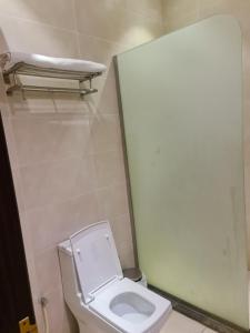 a bathroom with a white toilet and a shelf at Dshale Chalets in Taif