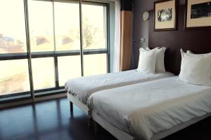 Postel nebo postele na pokoji v ubytování Hôtel Du Centre Annemasse