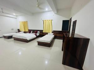 a living room with two beds and a couch at Hotel Maurya Vihar Bodhgaya in Bodh Gaya