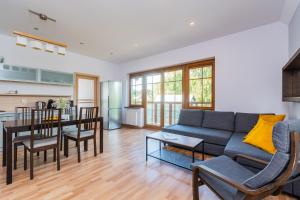 a living room with a couch and a table at Apartamenty NCNK Willa Turkusowa in Kąty Rybackie