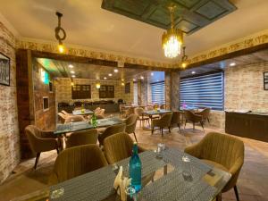 ein Restaurant mit Tischen und Stühlen in einem Zimmer in der Unterkunft Hotel Green Rooms, Vintage Luxury Near Dal Lake in Srinagar
