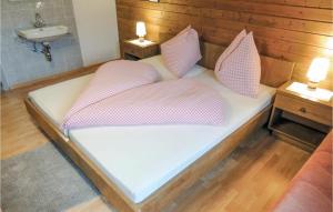 a bed with pink and white pillows and a sink at Stunning Apartment In Pfunds With 5 Bedrooms And Wifi in Pfunds