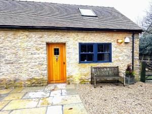 ein Backsteinhaus mit einer Holztür und einer Bank in der Unterkunft Dove House Cottages - No 1 in Oxford