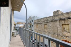 - un balcon avec des voitures garées sur le bâtiment dans l'établissement Fully equipped home, with balcony in St Julians by 360 Estates, à San Ġiljan