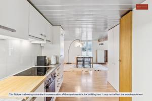 eine Küche mit weißen Schränken und ein Esszimmer in der Unterkunft Affordable Living on Zurich's Edge in Dietikon